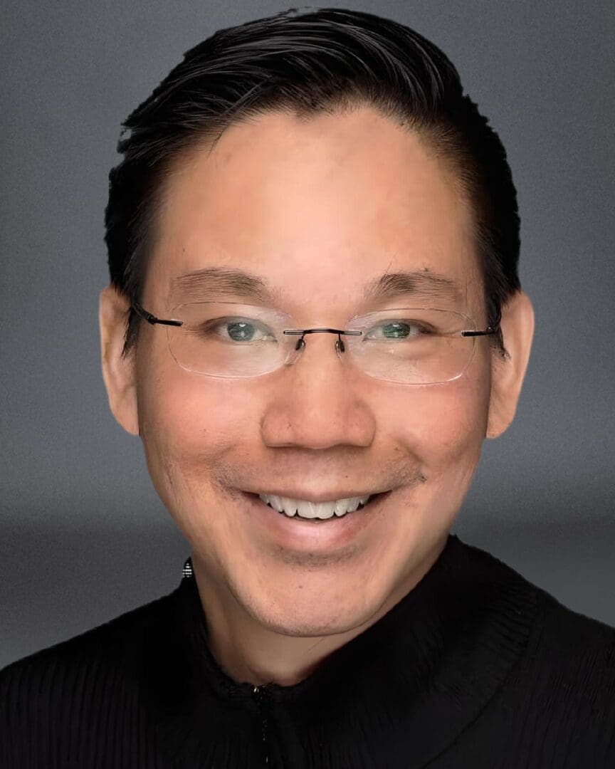 An asian man wearing glasses and a black shirt.